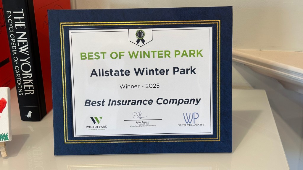 Framed award plaque reading “Best of Winter Park, Allstate Winter Park, Winner - 2025, Best Insurance Company,” with logos for Winter Park Chamber of Commerce and Winter Park Magazine, placed on a white surface near books.
